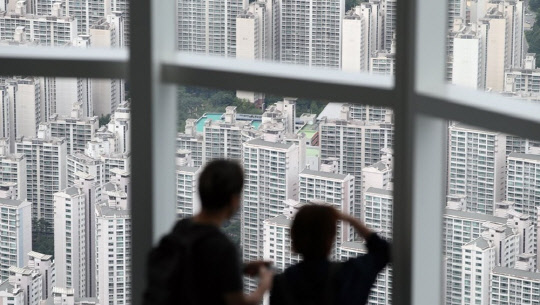 시민들이 서울 롯데월드타워 전망대 '서울스카이'에서 송파구 일대 아파트 단지를 바라보고 있다.  <연합뉴스>